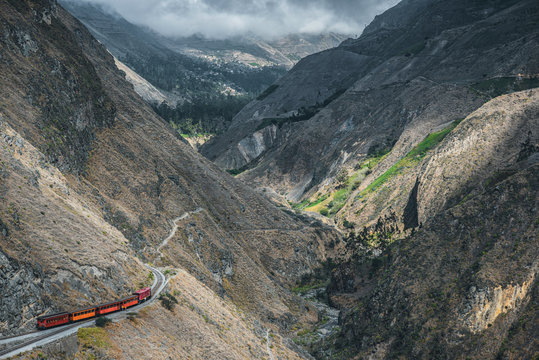 Red train going through the mountain landscape of Chimborazo province, Ecuador
