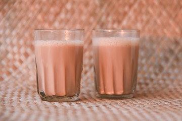 Top view of Indian Masala Chai or traditional milk tea beverage with milk and spices Kerala India. Two cups of organic ayurvedic or herbal drink India, good in winter for immunity boosting.