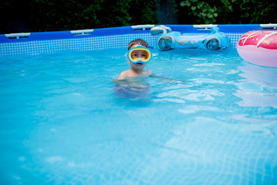Little boy with having fun in pool at back yard