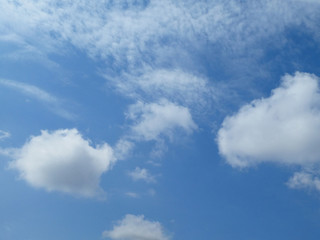 The blue cloudy sky with white clouds background and texture