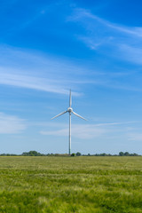 A symbol for green energy, wind turbine on a green field at Fehmarn in Schleswig Holstein Germany.