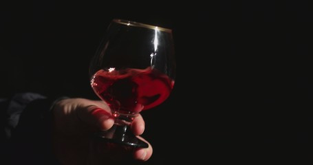 Fototapeta na wymiar Sommelier in front of a black background tastes red wine