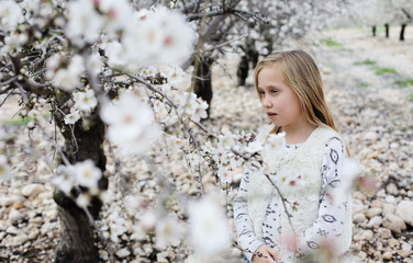 9 year old girl walking in the spring garden during the trees flowering