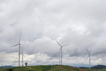 Fototapeta na wymiar Wind turbines in rainy day. Wind turbine with cloudy sky in background.