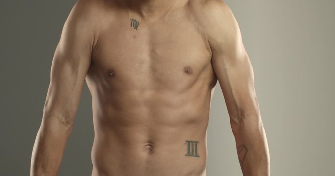 Physical strength, bodybuilding and sports concept. Close-up of sportsman naked chest, torso with abdominal abs. Male athleted showing flexed biceps, posing with arms tensed