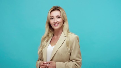 Wondered cheerful woman with sarcasm and derision pointing finger at camera and smiling, making fun of people, egoism. Indoor studio shot isolated on blue background - Powered by Adobe
