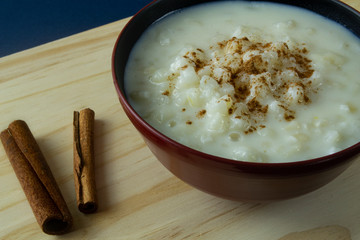 Hominy bowl with cinnamon sprinkled on wooden board