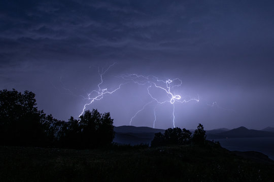 Curly shaped lightning strike over mountain range in Ural