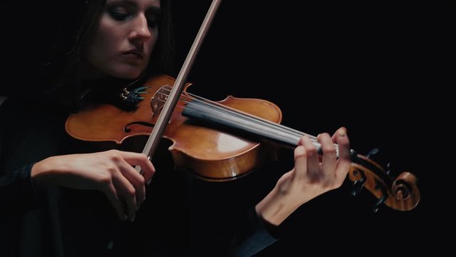 Girl violin musician playing at studio. Studio black background