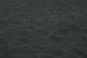 sand uneven waves highlighted by the sun sand background on the sea river lake summer