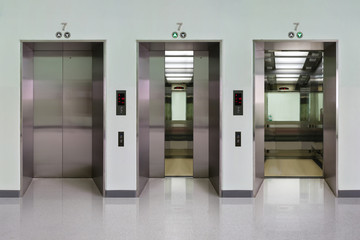 Open and closed chrome metal office building elevator doors realistic photo. Lift transportation floor to floors with push switch for up and down. © Sanit