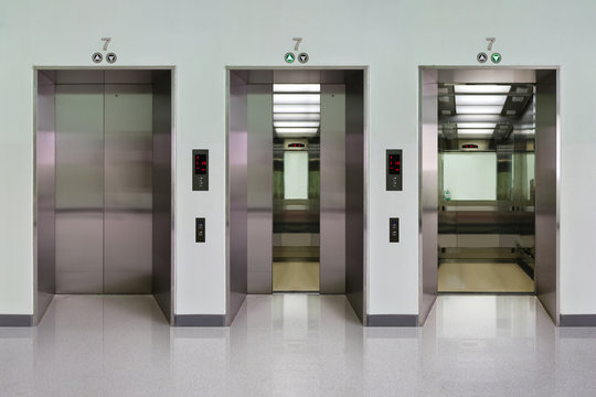 Open and closed chrome metal office building elevator doors realistic photo. Lift transportation floor to floors with push switch for up and down.