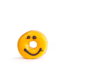 Fresh yellow donut with a chocolate smile isolated on white background with soft shadow