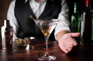 bartender serving martini in glass at bar