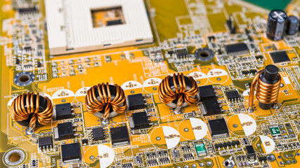 Four inductors with ferromagnetic core on circuit board of computer mainboard. Electrical...