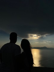 silhouette of a couple on the beach admiring sunset