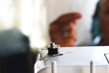 Obraz na płótnie Canvas Tailor wrapping a bobbin on the sewing machine