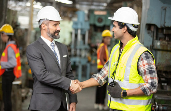 Business Director And Mechanic Engineer Hand Shaking At Factory Shop Floor.