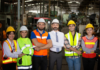Group of Engineer manager and Factory Workers Team standing against production line.