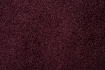 Fototapeta premium Close up of natural burgundy suede leather background. Suede texture macro shot. 