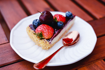 Blueberry cheesecake with fresh berries on white plate