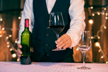 Waitress man pouring wine into glass