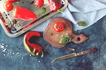 Red vegetables tomatoes and peppers, spices on the table, top view, healthy seasonal food concept, home cooking