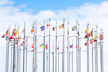 A lot of national flags of european countries on flagpoles abova blue sky. Concept of global union © Sunny_Smile