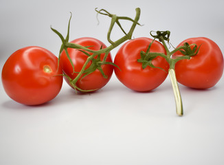 Czerwone, soczyste pomidory na białym tle.