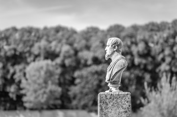 Statue in front of woods. Black and white.