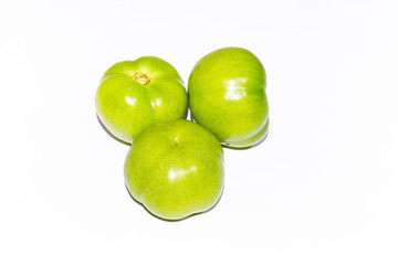 Green tomatoes over white isolated background.