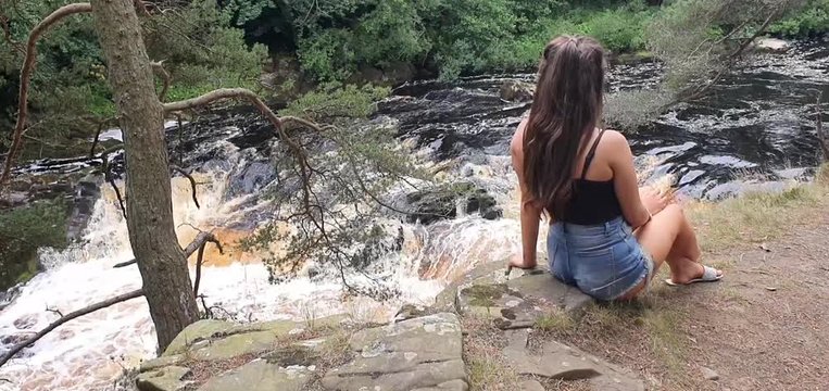 young girl relaxing by waterfall uk