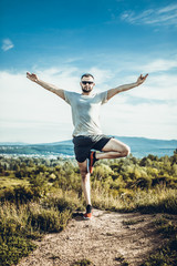 Young bearded man traveler feet standing alone with sunset mountains on background. Lifestyle travel concept outdoor.