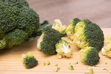 Fresh green broccoli on a wooden cutting board. Macro photo green fresh vegetable broccoli. Green Vegetables for diet and healthy eating. Organic food preparation.