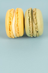 Cake macaron or macaroon on turquoise background from above, colorful almond cookies, pastel colors, vintage card