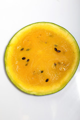 Slice of yellow watermelon on a white background.