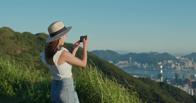 Woman take photo on cellphone at mountain