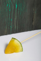 Pieces of yellow watermelon on sticks.
