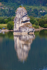 Fototapeta na wymiar Piatra Teiului natural limestone in water. Lake Bicaz, Romania and lonely stone