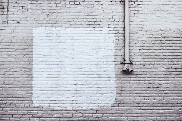 Old crumbling brick wall with white paint in a square © soupstock