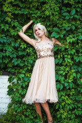 Young beautiful blonde in ivy, summer park outdoors