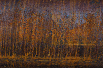 the surface of a metal pipe with water stains, taken on a cloudy summer day