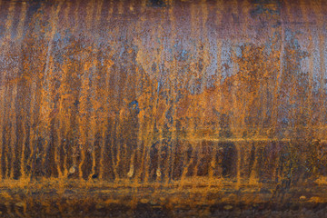 the surface of a metal pipe with water stains, taken on a cloudy summer day