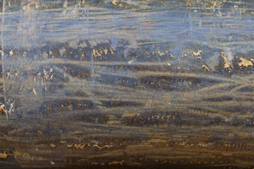 the surface of a metal pipe with water stains, taken on a cloudy summer day