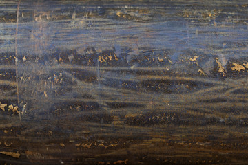 the surface of a metal pipe with water stains, taken on a cloudy summer day