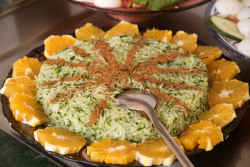 Moroccan traditional cuisine: grated cucumber salad with cinnamon, garnished with oranges. 