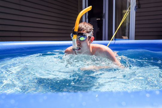 Teen swimming on a tether using a snorkel in an inflatable pool to practice during the pandemic