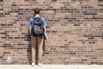 Fototapeta na wymiar Student blending into brick wall, an anonymous educational commodity