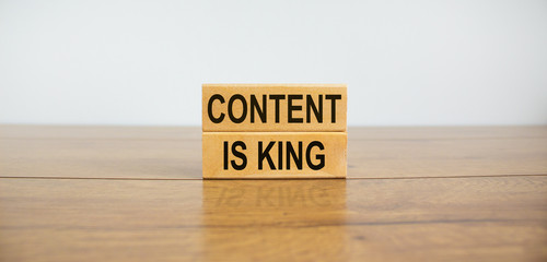 Wooden blocks form the text 'content is king' on beautiful wooden table, white background. Business concept, copy space.