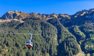 Cable car running towards Mannlichen (Maennlichen) from Wengen, famous tourist destination in Swiss...